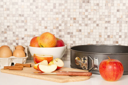Ingredients and tools to make a apple pie on white kitchen table