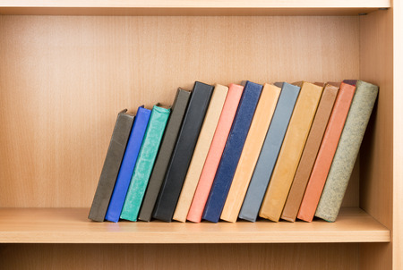 Old books on a wooden shelfの写真素材