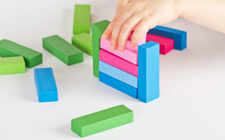 Child hands playing with colorful wooden blocks
