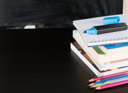 School books and marker against blackboardの写真素材