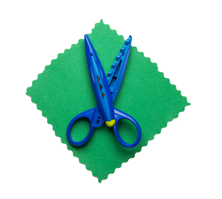 Open scissors for kids on colored paper isolated on white backgroundの写真素材