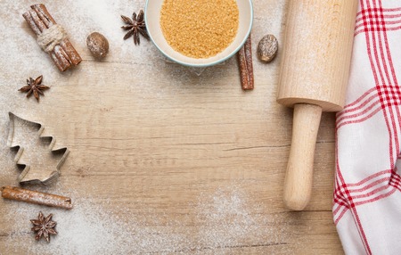 Baking christmas cookies-cuttery,cinnamon,anise, hazelnuts on wooden background