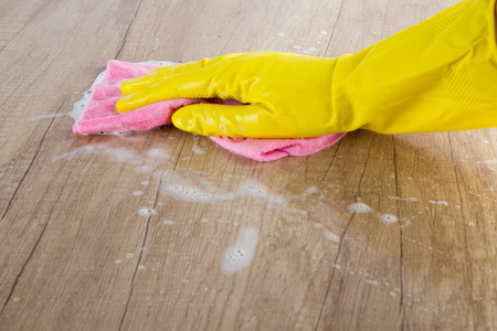 Woman's hand cleaning on a wooden backgroundの写真素材