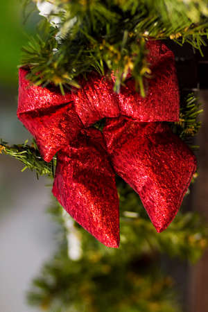 Red bow and fir branches.. Christmas decoration on the street. Wooden backgroundの写真素材