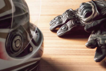 Motorcycle helmet, gloves, and road maps on a wooden table. Journey Dream. Travel route.の写真素材