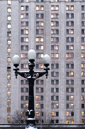 Main building of the Lomonosov Moscow State University. MGU. The Sparrow Hills, Moscow, Russia. Winter. The old street lamp on the wall background Universityの写真素材