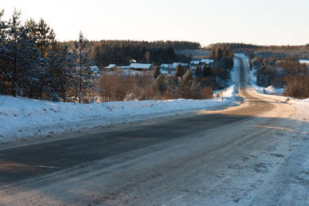 Snow-covered road on a winter day. Travel north Russia. Snow-covered road. Logging roads. Frosty sunny day. Russian northern villageの写真素材