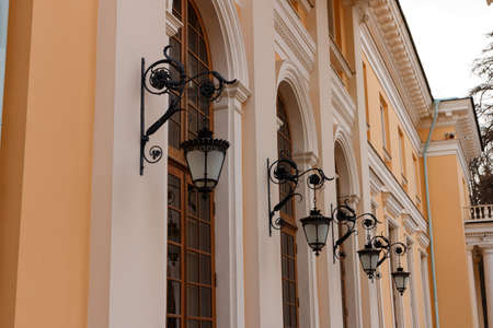 Image of beautiful retro vintage sophisticated street lamps hanging in row on wall. Wrought lantern on the wall of a classical buildingの写真素材