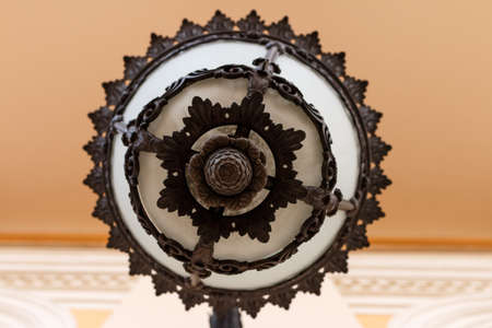 Wrought lantern on the wall of a classical building. Bottom view. Looks like a bumpkinの写真素材