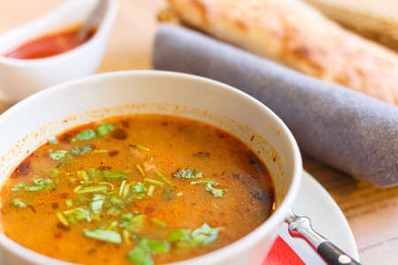 Soup kharcho, sprinkled with fresh herbs. Traditional Georgian soup Kharcho with meat and rice on...