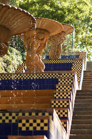 Drops of water sparkle in the sun. Fountain in the park. Drops of water from a fountain in the shape of a shell. Fountain in the park.の写真素材