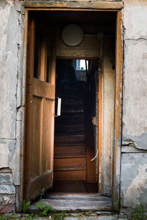 Entrance to an old abandoned house. A wooden staircase in an old abandoned house. Russian outback.