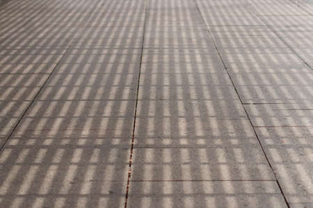 Shadow from a pergola on a road tile. Shading of city. Walkable environment. Abstract pattern....
