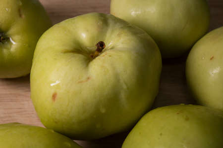 Green apples on a wooden table. Garden apples. Golden apples. Farm products. Juicy fruit.の写真素材