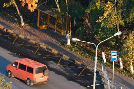 Autumn in the city. Bus stop among the autumn trees. Colors of autumn. View from above.の写真素材