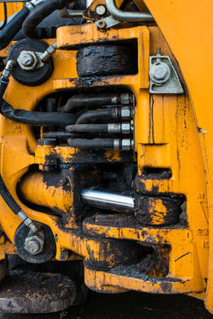 Interlacing of hoses and tubes. Detail of the industrial mechanism. Dirty elements of a construction machine. Fragment of a tractorの写真素材