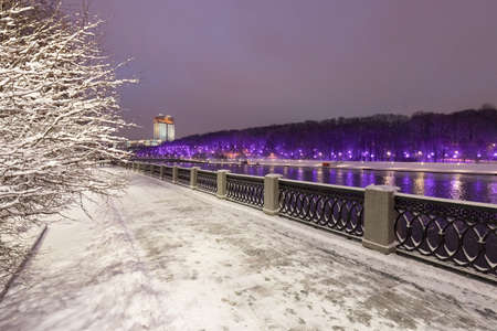 Moscow. Russia. Winter snow-covered city landscape. View from the Luzhnetskaya embankment to the Muskva River, Vorobyovy Gory and the Russian Academy of Sciences building with an evening illumination.の写真素材