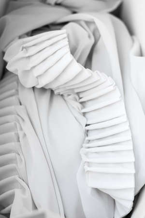 The folds of white chiffon. Abstract composition. Waves of fabric. Pattern from the waves of the curtain. Abstract soft chiffon texture backgroundの写真素材