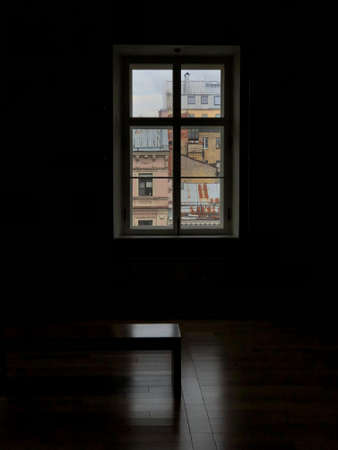 View of St. Petersburg from the dark room of the museum. View of old buildings with rusty roofs from a dark room with a bench and parquet floor.の写真素材
