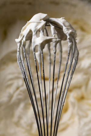 Whisk for whipping cream. Cooking cream. Metal whisk for mixing.