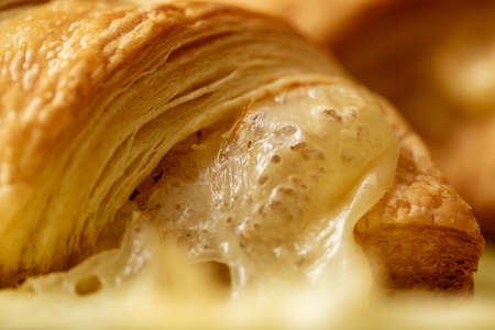 Croissant with cheese. Fresh bakery. Bread bakery. Closeup of croissant with melted cheese.