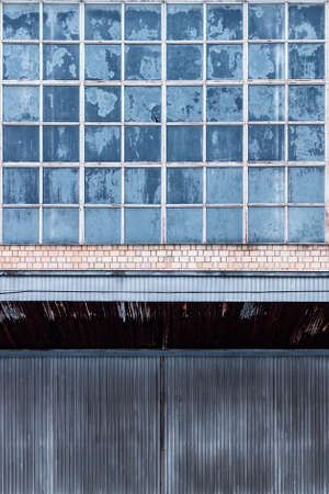 Architectural abstraction. The facade of an old industrial building. Large window with frosty...