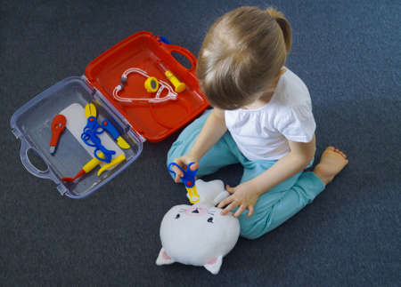 Kid playing doctor with medical tools toy kit. Top view. Medical, health care and game concept. High quality photoの写真素材