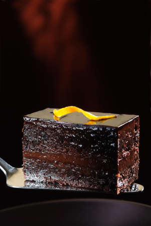 Piece of dark chocolate cake on a spatulaの写真素材