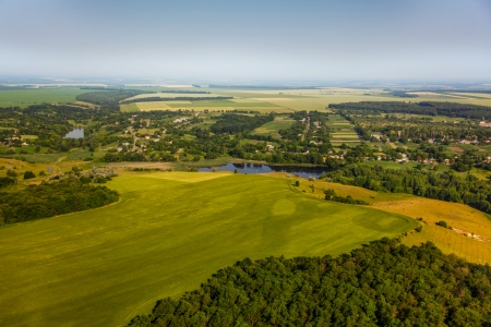aerial view above the village and green fieldsの写真素材