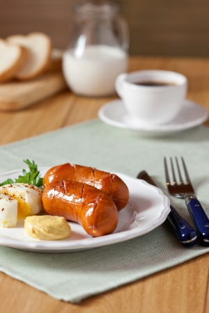 Two grilled sausages on white dishの写真素材
