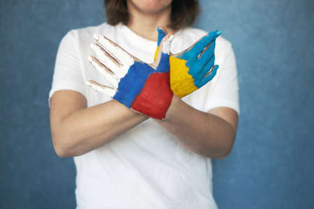 Peace symbol dove made from female hands colored in russian and ukraine flags colors. No war, stop