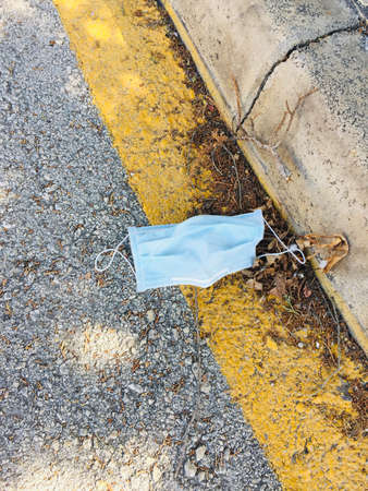 Medical face mask on the floor in the street. Disposable face mask. Improperly done.の写真素材