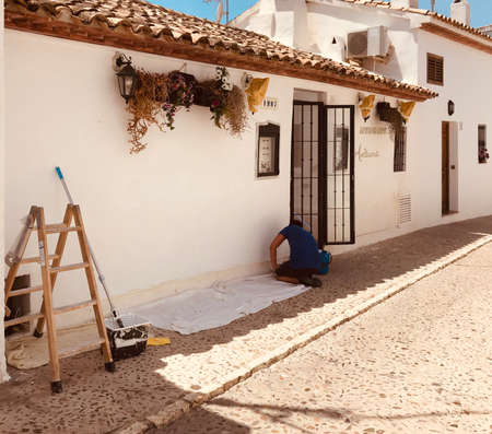 Altea, Spain, 02,06,2020:Painter man, painting the restaurant wall, getting ready for re-open during phase 2 of lock down in Spain.のeditorial素材