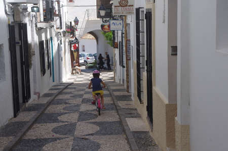 Altea, Spain, 01-06-2020: Little girl with a bike and her mask enjoying freedom during covid 19. Phase 2 in Spain.のeditorial素材