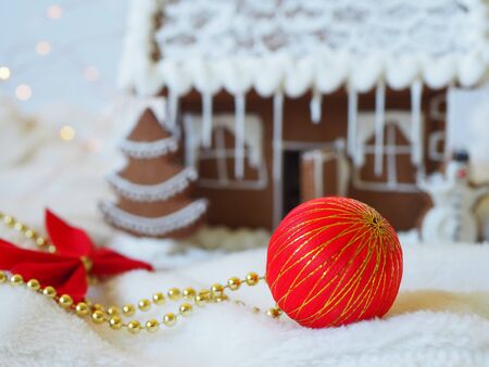 Christmas ball in front of a gingerbread house in the backgroundの写真素材