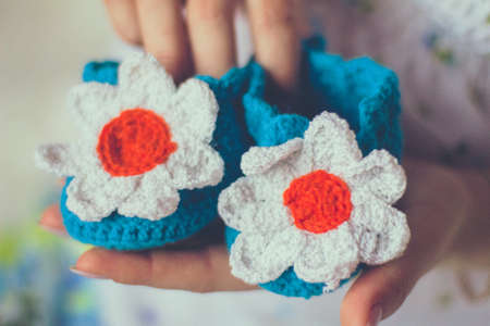 Baby knitted slippers in handsの写真素材