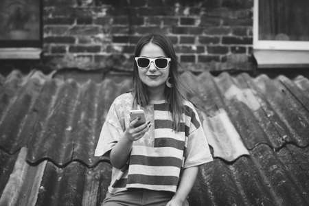Hipster girl in the old courtyard with phoneの写真素材