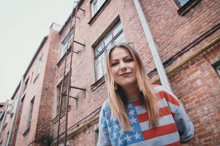 A hipster girl in an old courtyard posing and smilingの写真素材
