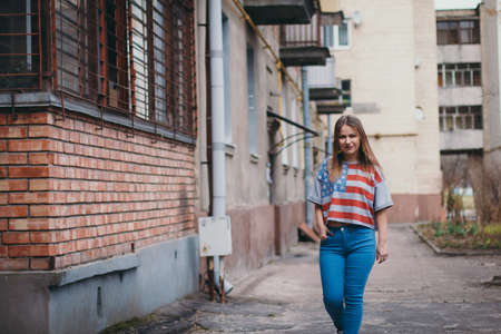 A hipster girl in an old courtyard posing and smilingの写真素材
