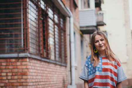 A hipster girl in an old courtyard posing and smilingの写真素材