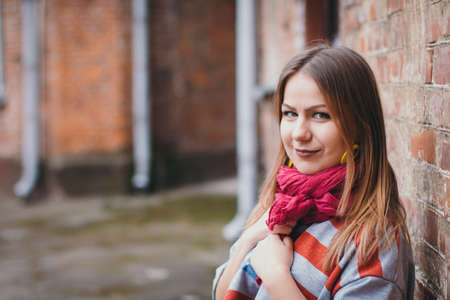 A hipster girl in an old courtyard posing and smilingの写真素材