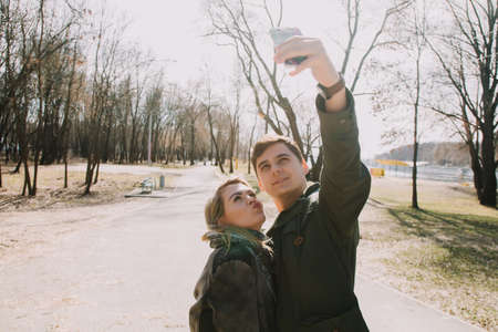 Cheerful loving each other couple kisses. Walk on the river bank and embraceの写真素材