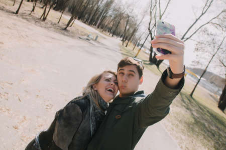 Cheerful loving each other couple kisses. Walk on the river bank and embraceの写真素材