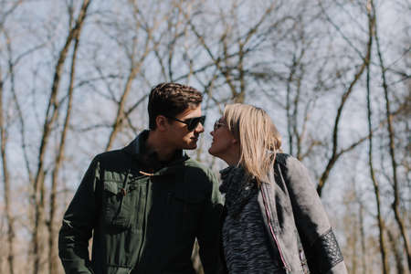 Cheerful loving each other couple kisses. Walk in the park and hug.の写真素材