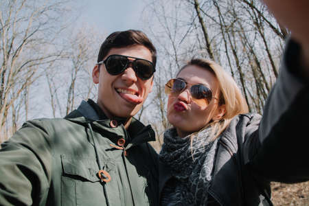 Cheerful loving each other couple kisses. Walk in the park and hug.の写真素材