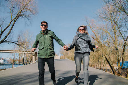 Cheerful loving each other couple kisses. Walk in the park and hug.の写真素材