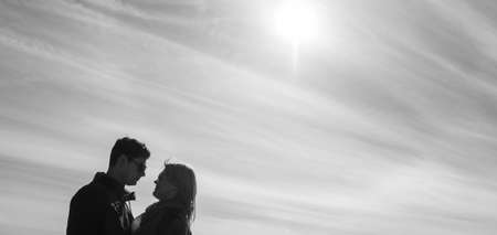 Beautiful loving each other couple is standing on the bridge smiling and kissing.の写真素材