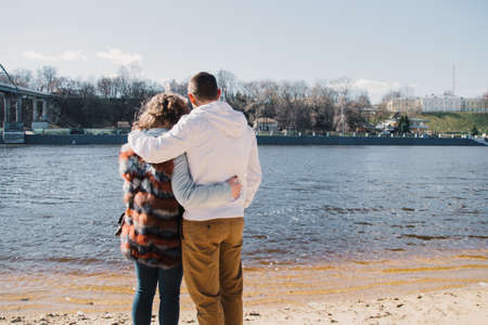 Happy couple in love hugging and sharing emotions, holding hands on the river bankの写真素材