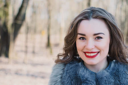 Portrait of a happy enamored girl in anticipation of a beloved man in the parkの写真素材