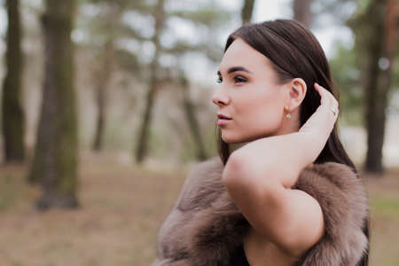 Portrait of a very beautiful girl in a forest dressed in furの写真素材